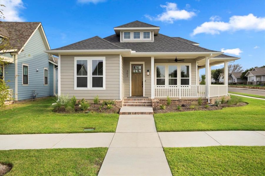 View of front of house with a front yard and covered porch