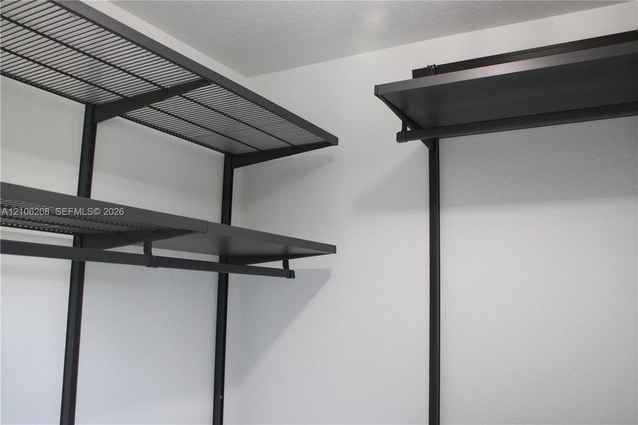 Customizable dark-finish metal shelving system featuring tiered wire racking and integrated hanging rods