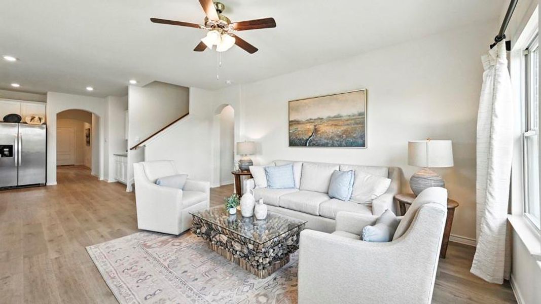 Bright living area featuring light-toned flooring, a ceiling fan, and recessed lighting