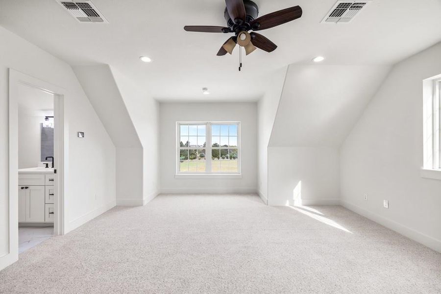 Additional upstairs living space/guest room with ensuite bath, light colored carpet, lofted ceiling, a ceiling fan, and recessed lighting Additional upstairs living space/guest room with ensuite bath, light colored carpet, lofted ceiling, a ceiling fan, and recessed lighting