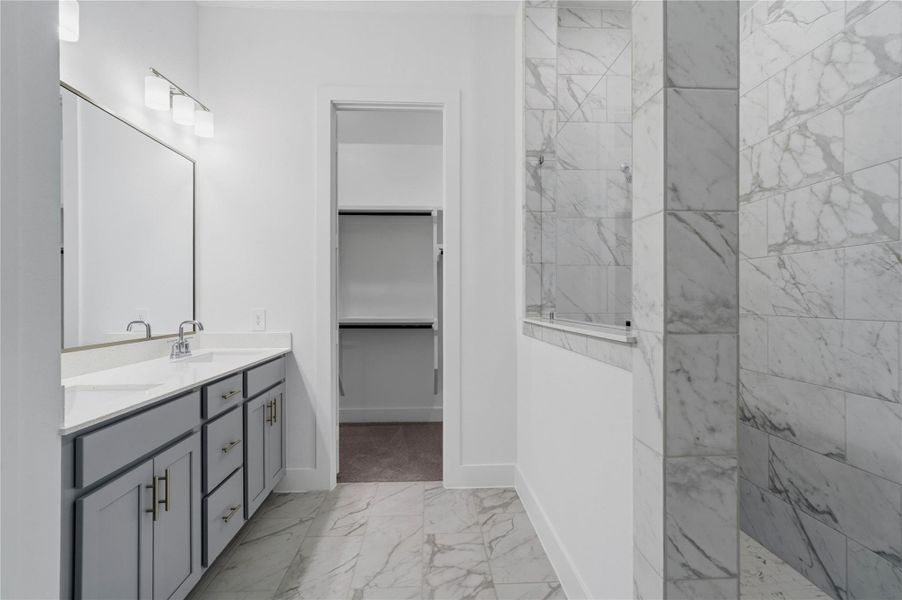 A bright and functional primary bath offering dual sinks for busy mornings, a large framed mirror, and a modern super walk-in shower, creating a serene and efficient space. A bright and functional primary bath offering dual sinks for busy mornings, a large framed mirror, and a modern super walk-in shower, creating a serene and efficient space.