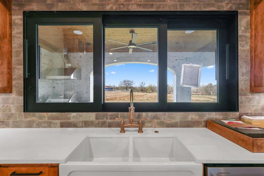Kitchen view of light stone counters and ceiling fan