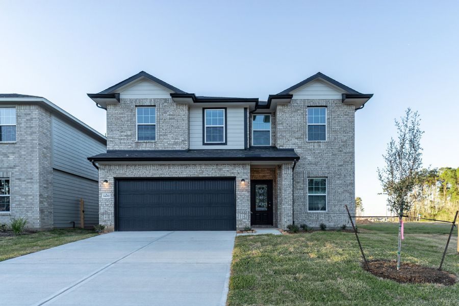 Front exterior of a new home in Caney Mills, Conroe, TX, highlighting curb appeal (Image 2).
