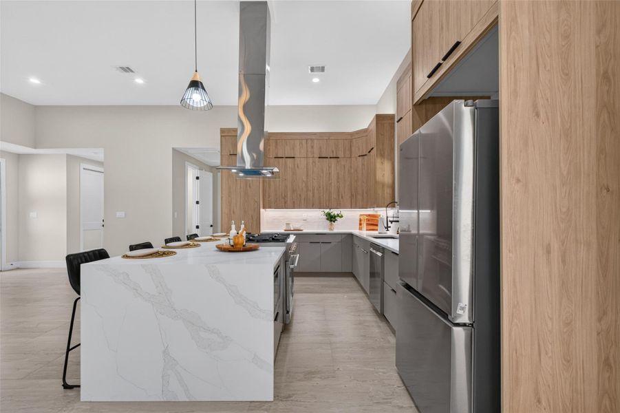 Sleek modern kitchen featuring a large marble island, stainless steel appliances, and stylish wood cabinetry, perfect for culinary enthusiasts and entertaining.