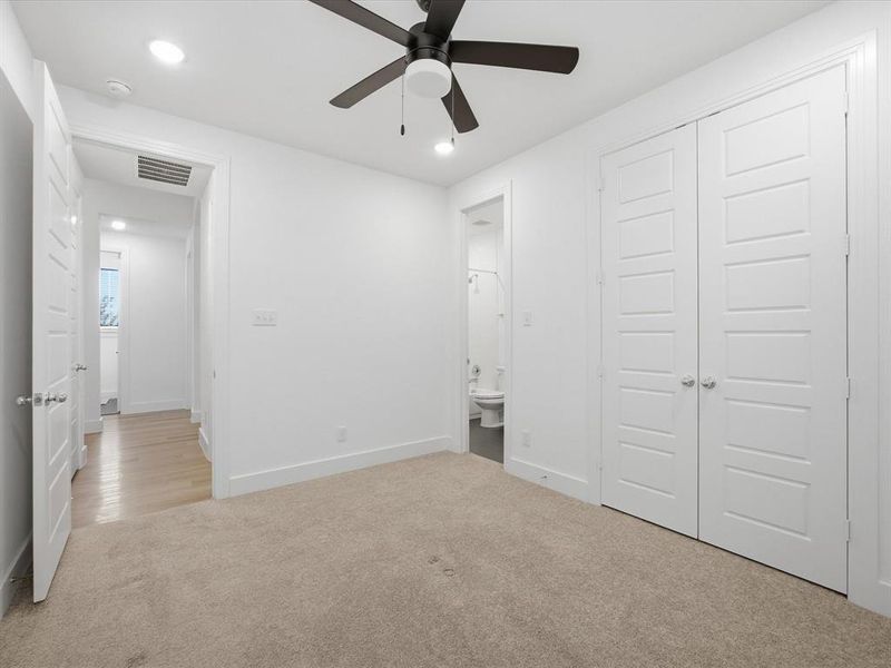 Unfurnished bedroom with light carpet, a closet, ensuite bathroom, recessed lighting, and ceiling fan