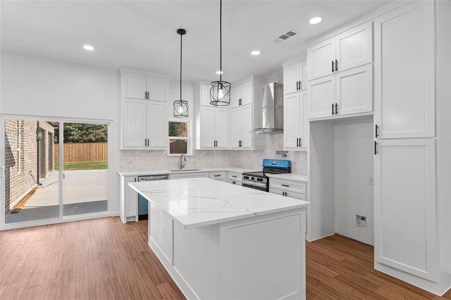 Kitchen featuring decorative backsplash, wall chimney range hood, dark wood-type flooring, white cabinets, and recessed lighting