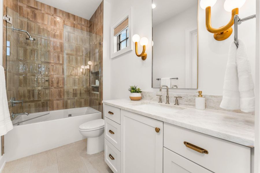 Bathroom featuring washtub / shower combination, vanity, and light tile patterned floors Bathroom featuring washtub / shower combination, vanity, and light tile patterned floors