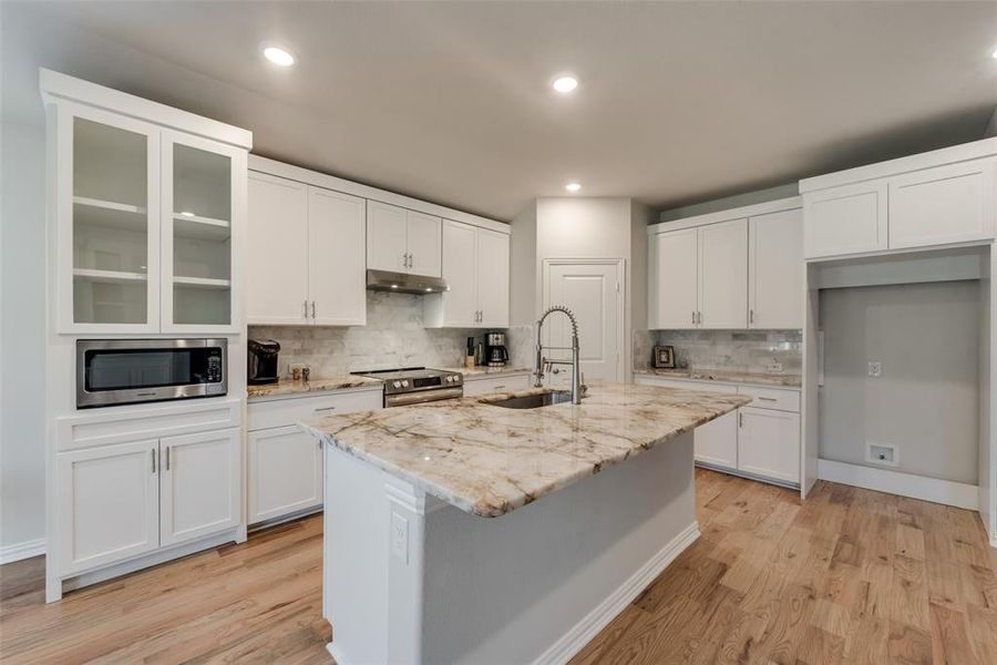 Kitchen featuring stainless steel appliances, built in microwave, Bosh dishwasher, convection oven and commercial style exhaust fan. Cabinets around fridge were designed to give the built-in look