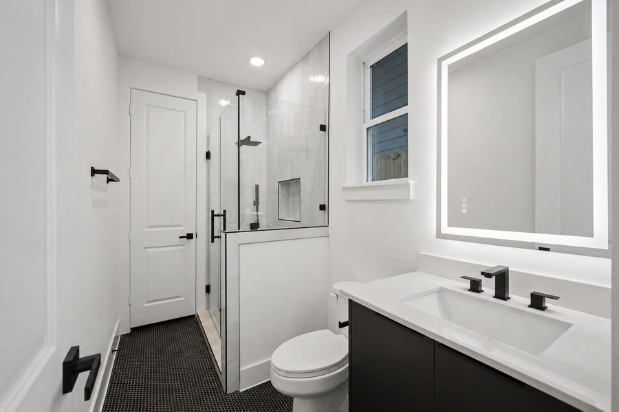 Full bath featuring designer finishes and classic penny tile flooring