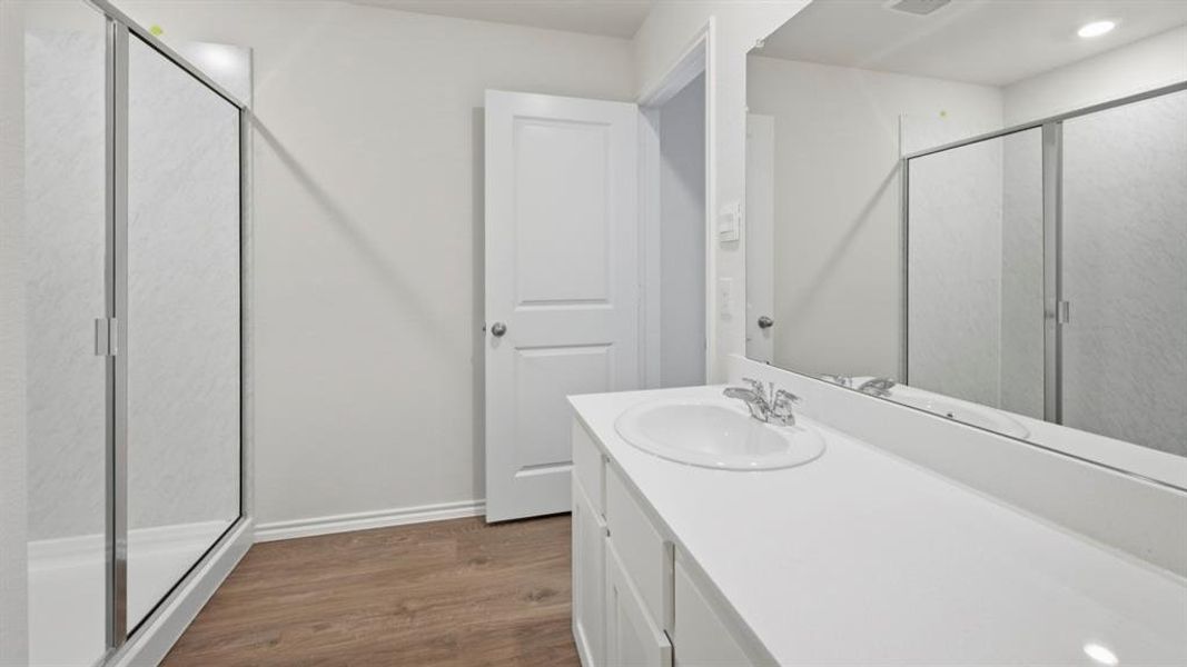 Full bath featuring a shower stall, vanity, and dark wood-type flooring Full bath featuring a shower stall, vanity, and dark wood-type flooring