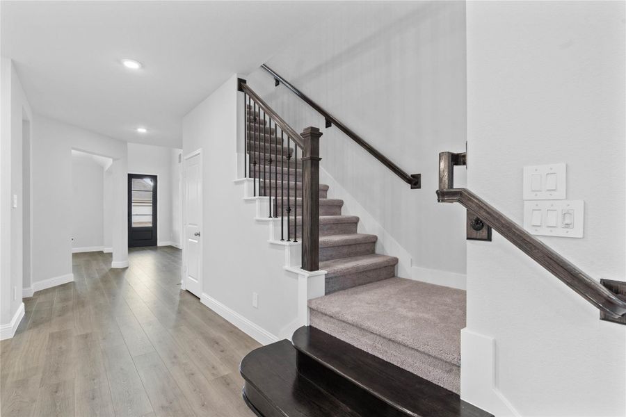 A centerpiece of the home, the stunning staircase showcases a sophisticated contrast of rich dark wood accents, crisp white trim, and sleek wrought iron spindles for a truly modern aesthetic.