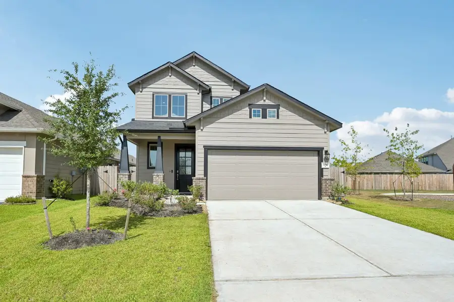 Charming two-story home with a modern facade, spacious driveway, and a well-maintained front yard.