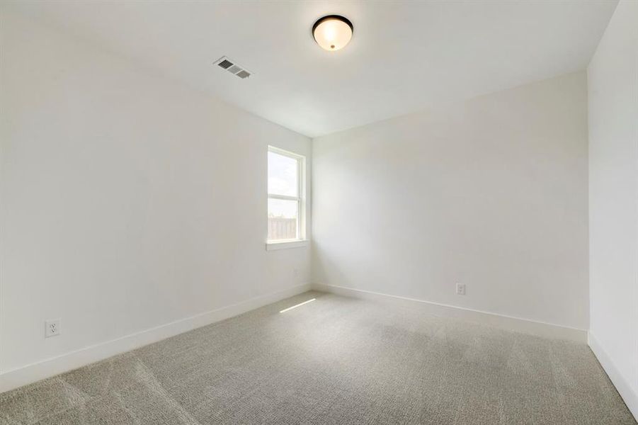 Bright room with white painted walls, a single rectangular window, light gray patterned carpet, white baseboards, and a flush-mount ceiling light fixture Bright room with white painted walls, a single rectangular window, light gray patterned carpet, white baseboards, and a flush-mount ceiling light fixture