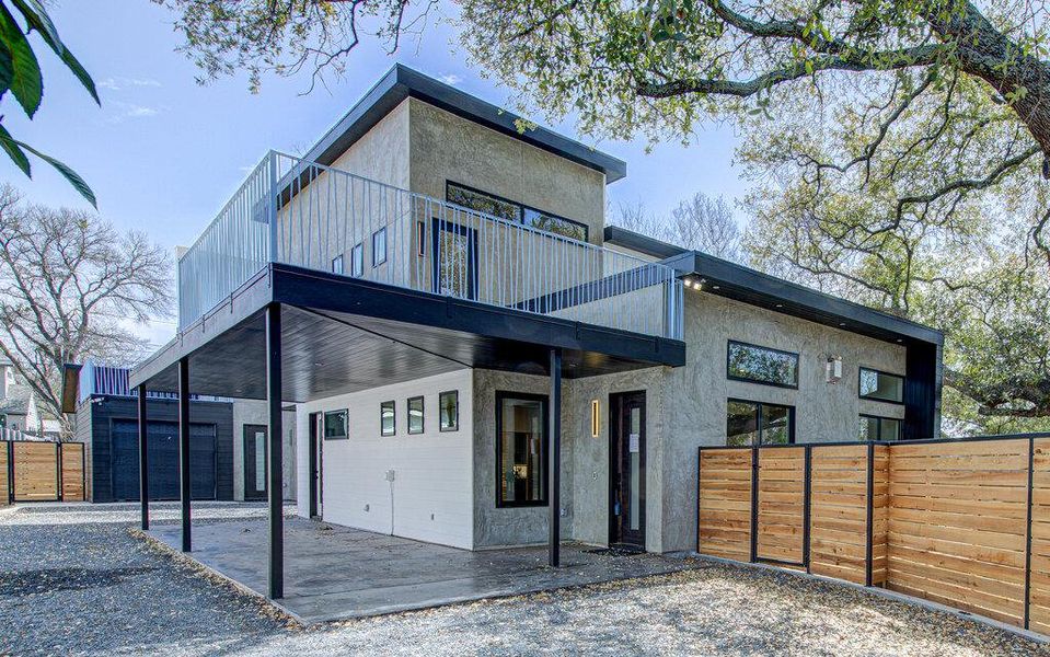 Modern home featuring a patio area, fence, a balcony, and stucco siding