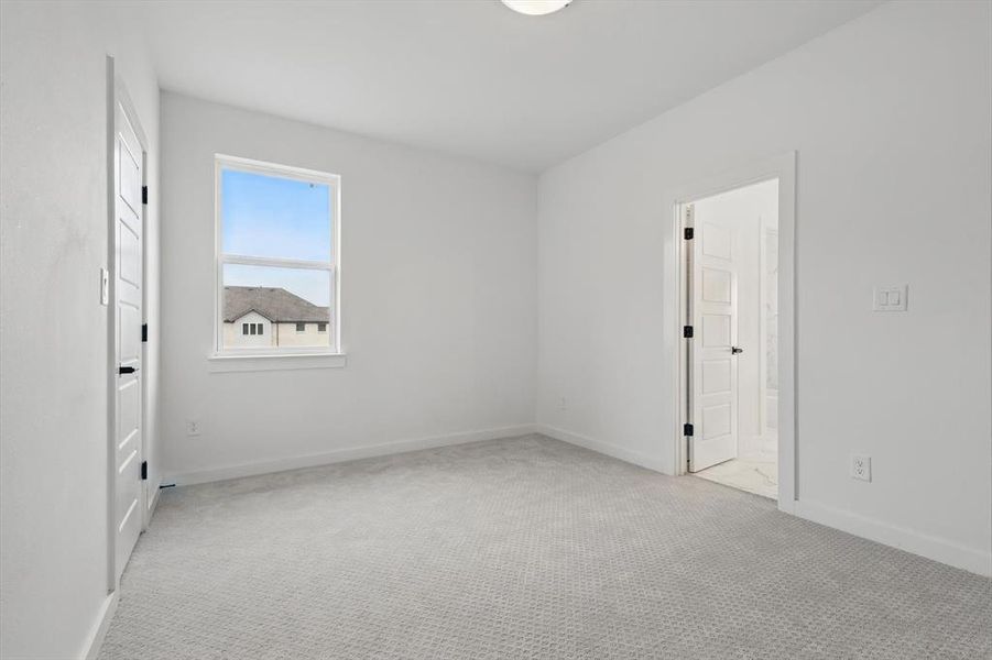 Unfurnished bedroom with carpet flooring, baseboards, and connected bathroom