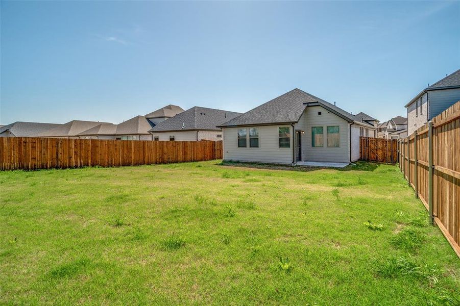 Rear view of house featuring a fenced backyard and a patio area