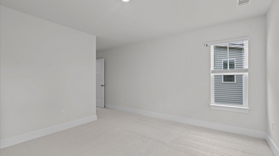 Carpeted secondary bedroom with walk-in closet in two story townhome at Aspen Ridge by DRB Homes in Lyman, SC Carpeted secondary bedroom with walk-in closet in two story townhome at Aspen Ridge by DRB Homes in Lyman, SC