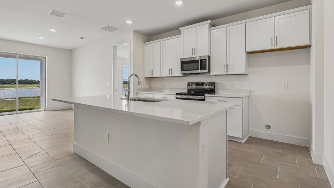 Longleaf Floor Plan Kitchen and Island with overhang for seating by DRB Homes in Trailside New Homes in Mount Dora Fl