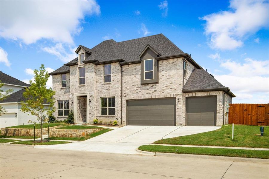 View of front of home featuring a garage and a front lawn