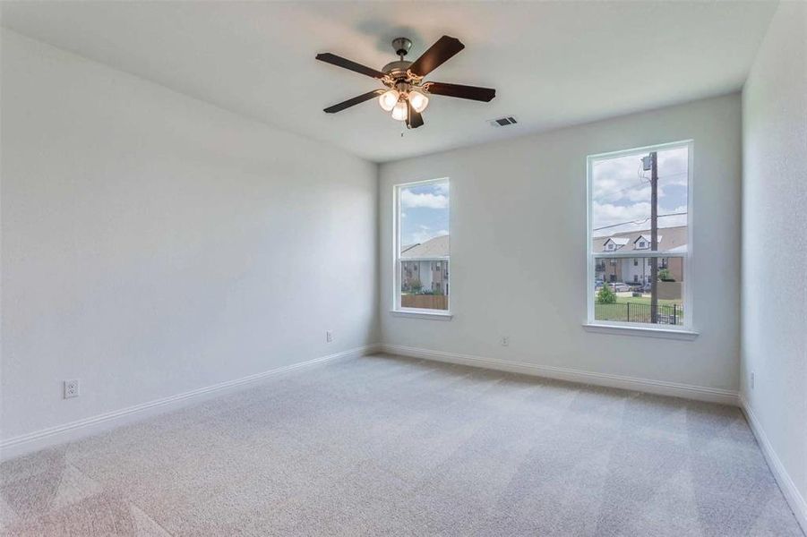 Empty room with light carpet and ceiling fan Empty room with light carpet and ceiling fan