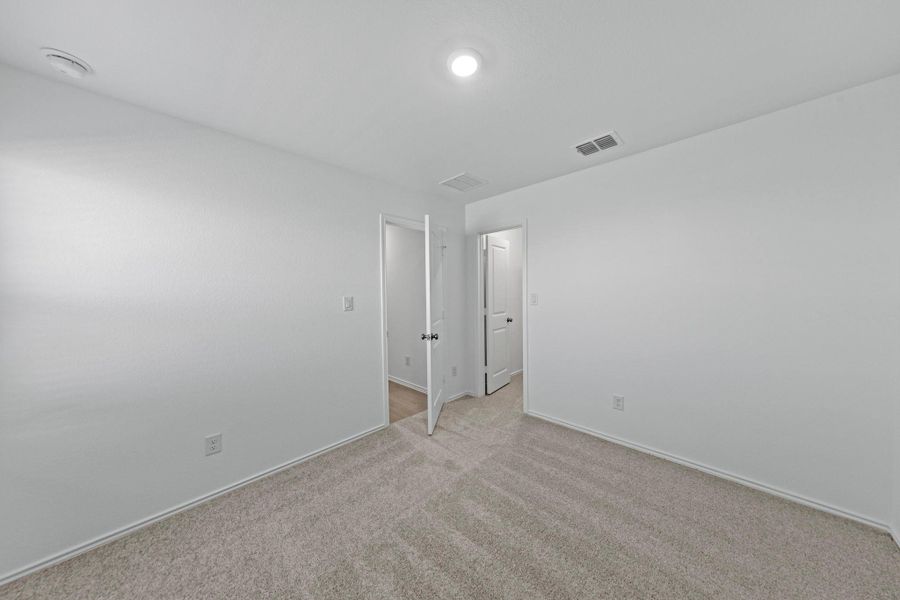 Empty room with carpet flooring and baseboards Empty room with carpet flooring and baseboards