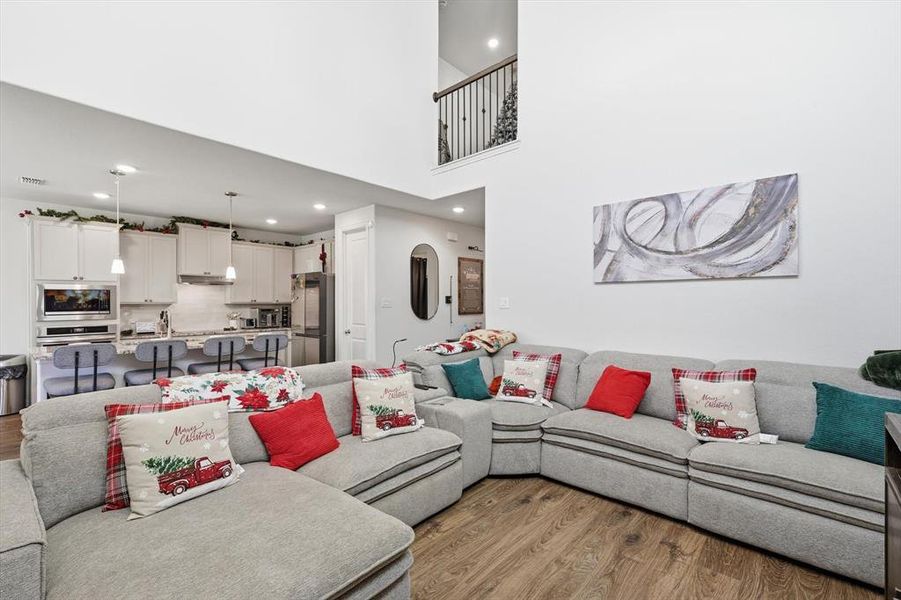 Living area with light wood-style floors and recessed lighting