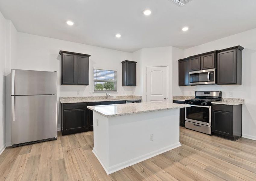 Stunning kitchen with a large island, granite countertops, and a large basin sink.