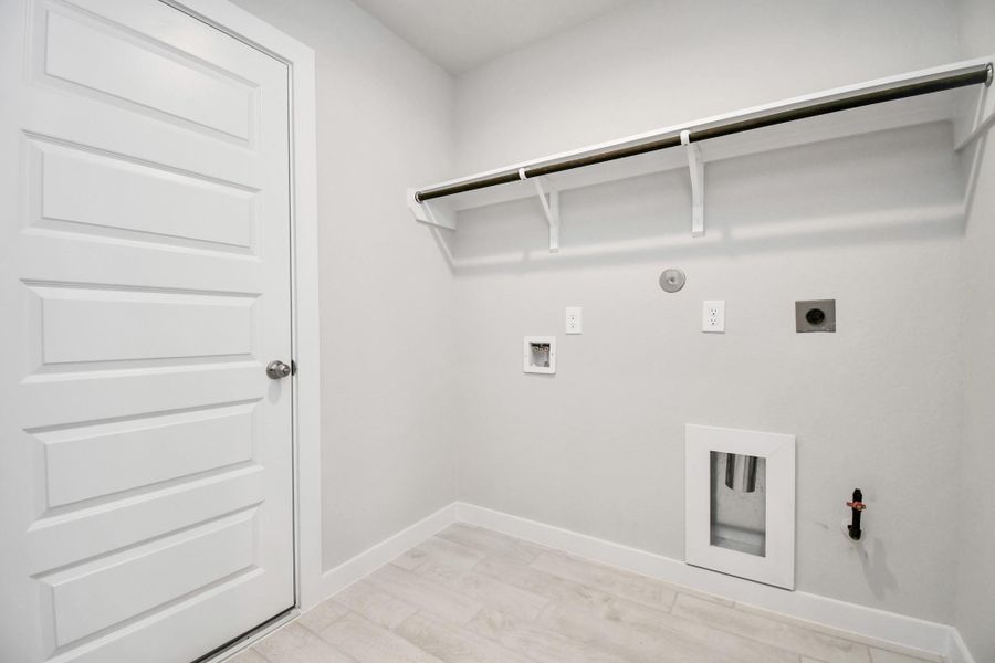 A perfect blend of functionality and comfort. Capture the essence of easy living with a first-floor laundry room, thoughtfully equipped with shelving for effortless organization. Both electric and gas connections available. Sample photo of completed home with similar floor plan. Actual colors and selections may vary. A perfect blend of functionality and comfort. Capture the essence of easy living with a first-floor laundry room, thoughtfully equipped with shelving for effortless organization. Both electric and gas connections available. Sample photo of completed home with similar floor plan. Actual colors and selections may vary.