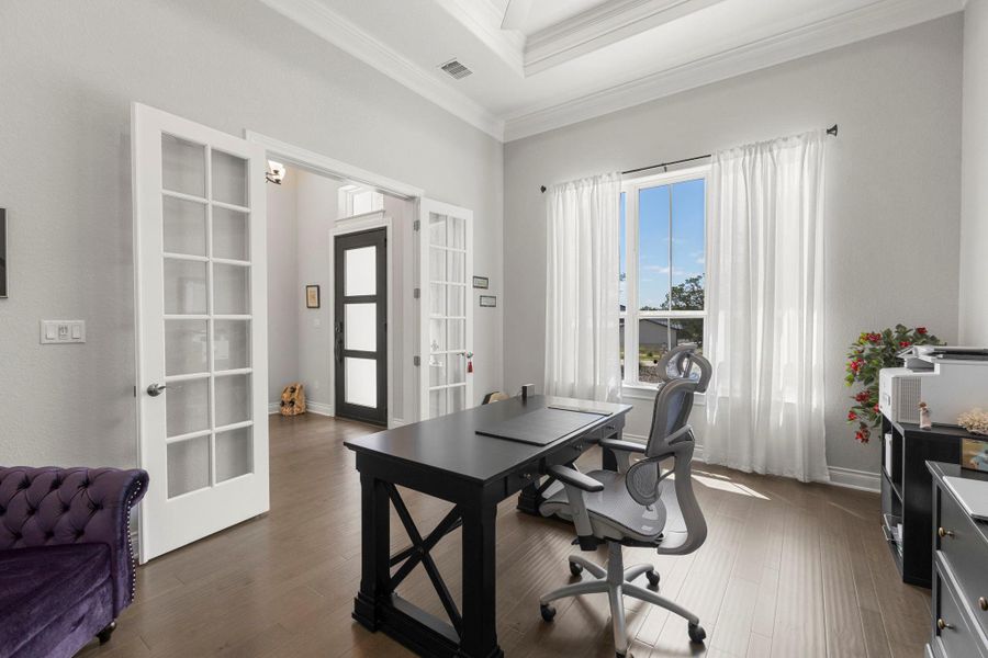 French doors and gleaming hardwood floors distinguish this inviting home office.