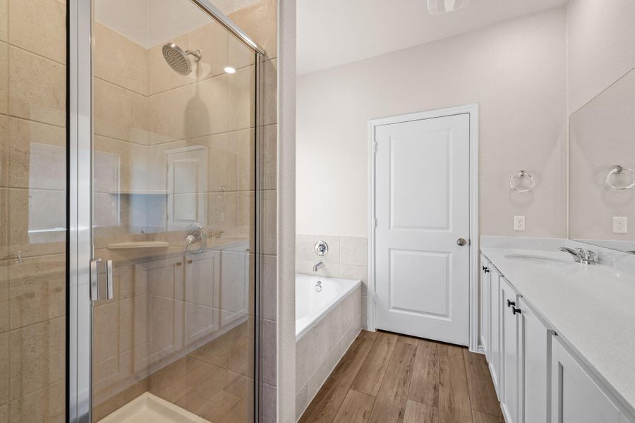 Bathroom with vanity, a garden tub, a stall shower, and light wood finished floors