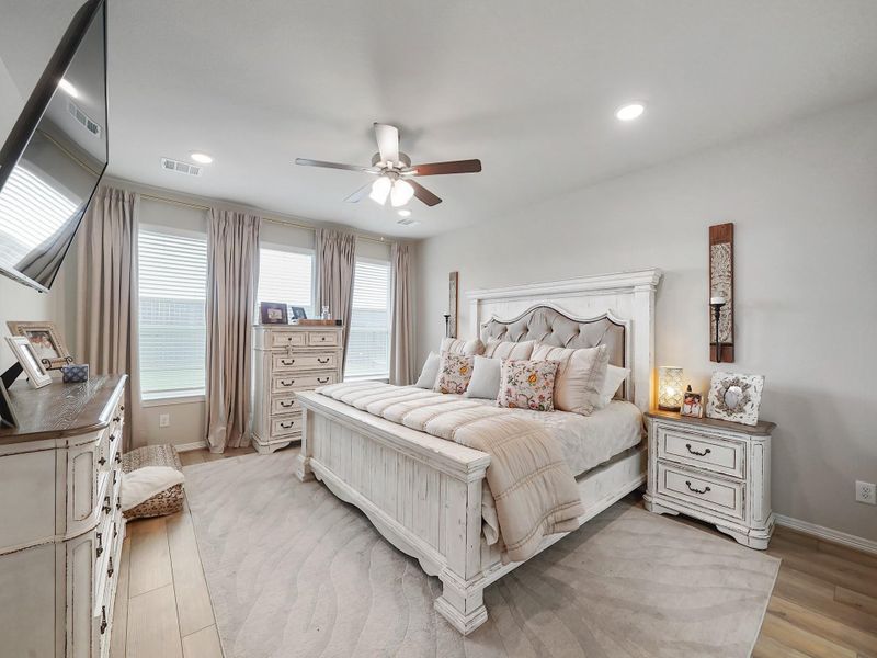 The primary suite is a peaceful retreat, offering generous space and a calming atmosphere designed for rest and relaxation.