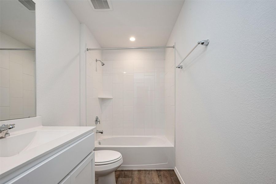 This full bathroom is cleanly styled with white tiling and a shower-tub combo. The white vanity offers under-cabinet storage and a wide mirror for everyday convenience. This full bathroom is cleanly styled with white tiling and a shower-tub combo. The white vanity offers under-cabinet storage and a wide mirror for everyday convenience.
