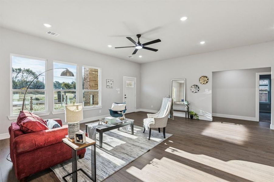 Living area with recessed lighting, a ceiling fan, and dark wood-type flooring