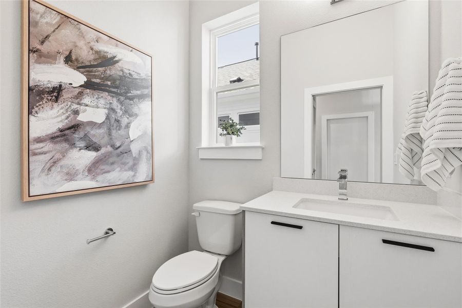 A discreetly placed powder bath, thoughtfully tucked away from the main living areas, ideal for guests to freshen up without interrupting the flow of the home.