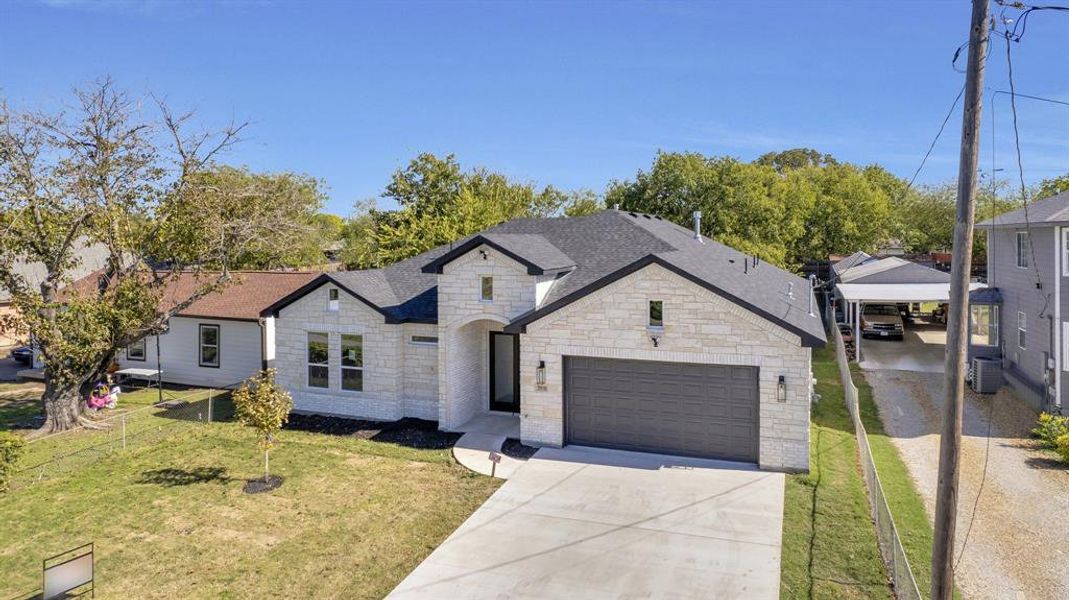 French provincial home featuring a garage, central air condition unit, and a front yard