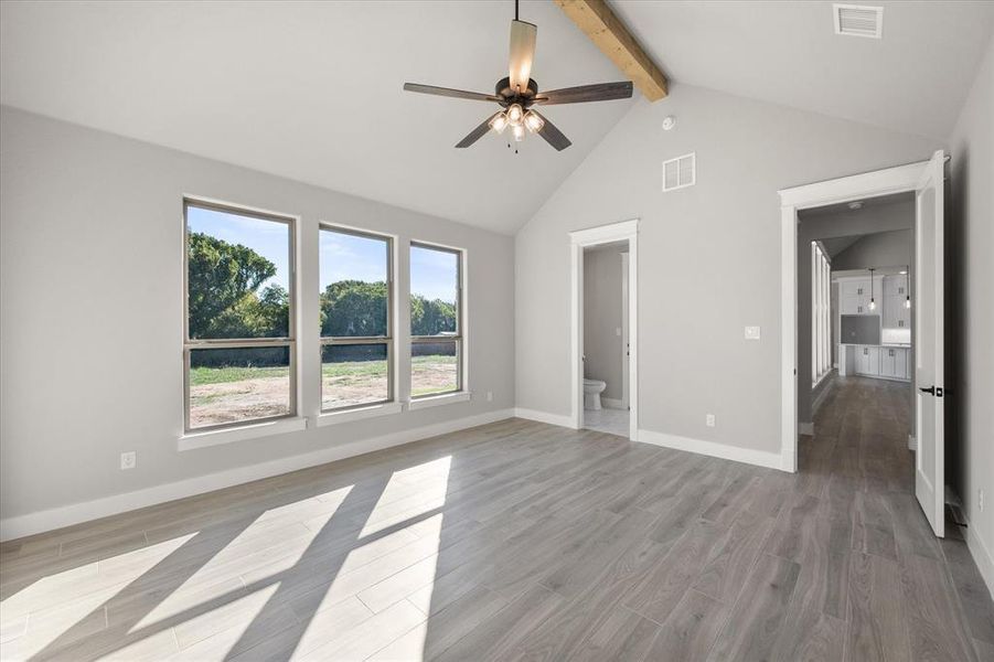 Beautiful gameroom with vaulted ceilings, views of the backyard and a connected half bath that has a door to the patio