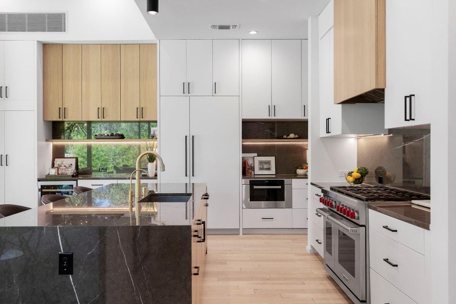 High-end appliances include an 8-burner built-in Wolf range with double ovens and a designer vent hood, plus a built-in Subzero fridge and freezer, dishwasher, and Wolf microwave, convention oven with warming drawer.