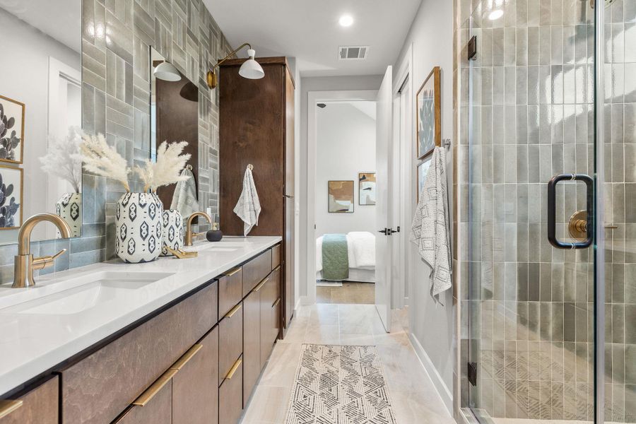 Ensuite bathroom with visible vents, a sink, a shower stall, and ensuite bath