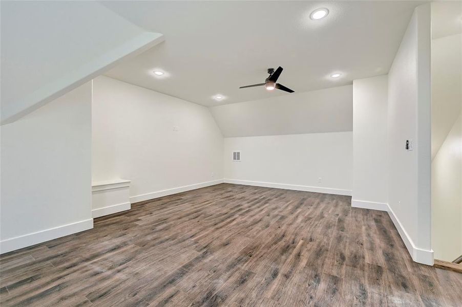 Bonus room featuring ceiling fan, vaulted ceiling, dark wood finished floors, baseboards, and recessed lighting