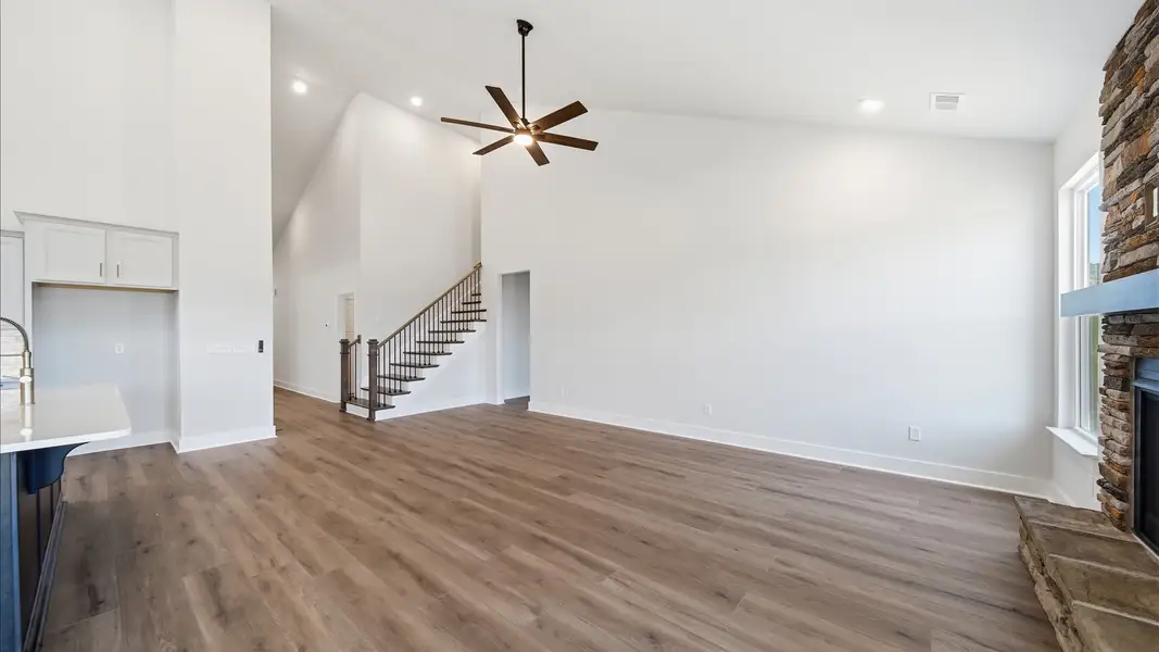 Spacious and stylish family room with two-story ceilings that create a bright and open atmosphere at Iris Meadows