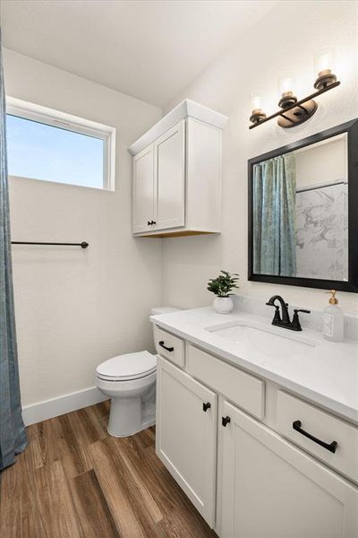 Bathroom vanity featuring a white countertop, undermount sink, and black faucet