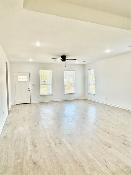 Unfurnished living room featuring light wood-type flooring, healthy amount of natural light, recessed lighting, and ceiling fan