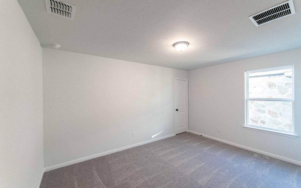 Carpeted spare room featuring a textured ceiling and baseboards