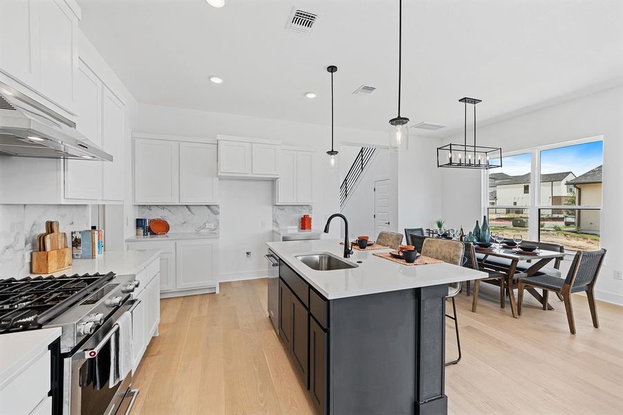 Open floorplan with kitchen and island open to dining area large windows supply natural light