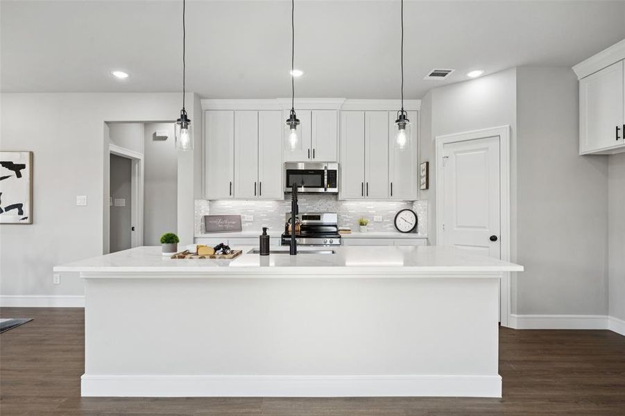 Kitchen featuring dark wood-style flooring, hanging light fixtures, white cabinetry, tasteful backsplash, and recessed lighting
