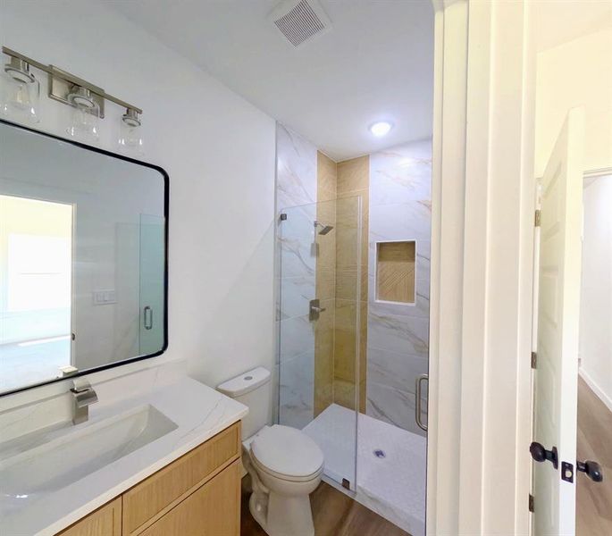 Full bathroom with vanity, a marble finish shower, and recessed lighting Full bathroom with vanity, a marble finish shower, and recessed lighting