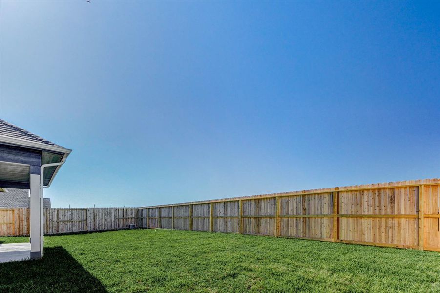 Fully fenced backyard with open green space ready for play, pets, or future landscaping.
