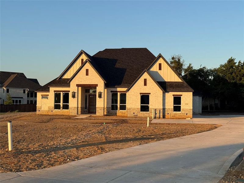 View of front facade with board and batten siding, brick siding, and a shingled roof View of front facade with board and batten siding, brick siding, and a shingled roof