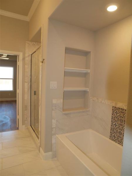 Bathroom featuring crown molding, tile patterned floors, plus walk in shower, and built in shelves