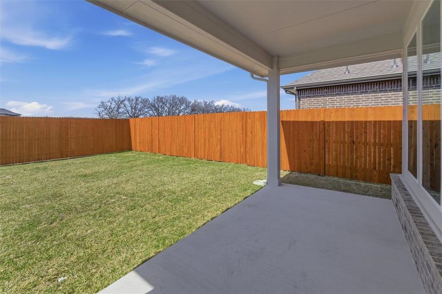 Fenced backyard with a patio